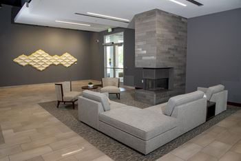 Community lounge complete with comfortable seating, cozy overhead lighting, and a fireplace.